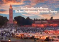 A vibrant evening scene at Jemaa el-Fnaa square in Marrakech, Morocco, with the Koutoubia Mosque in the background and a bustling market in the foreground.